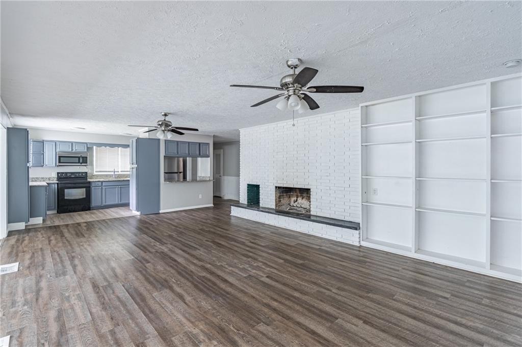 8035 Rockbridge Road Southwest Lithonia, GA 30058 - Photo 10 of 39 a view of a livingroom with a hardwood floor and a ceiling fan
