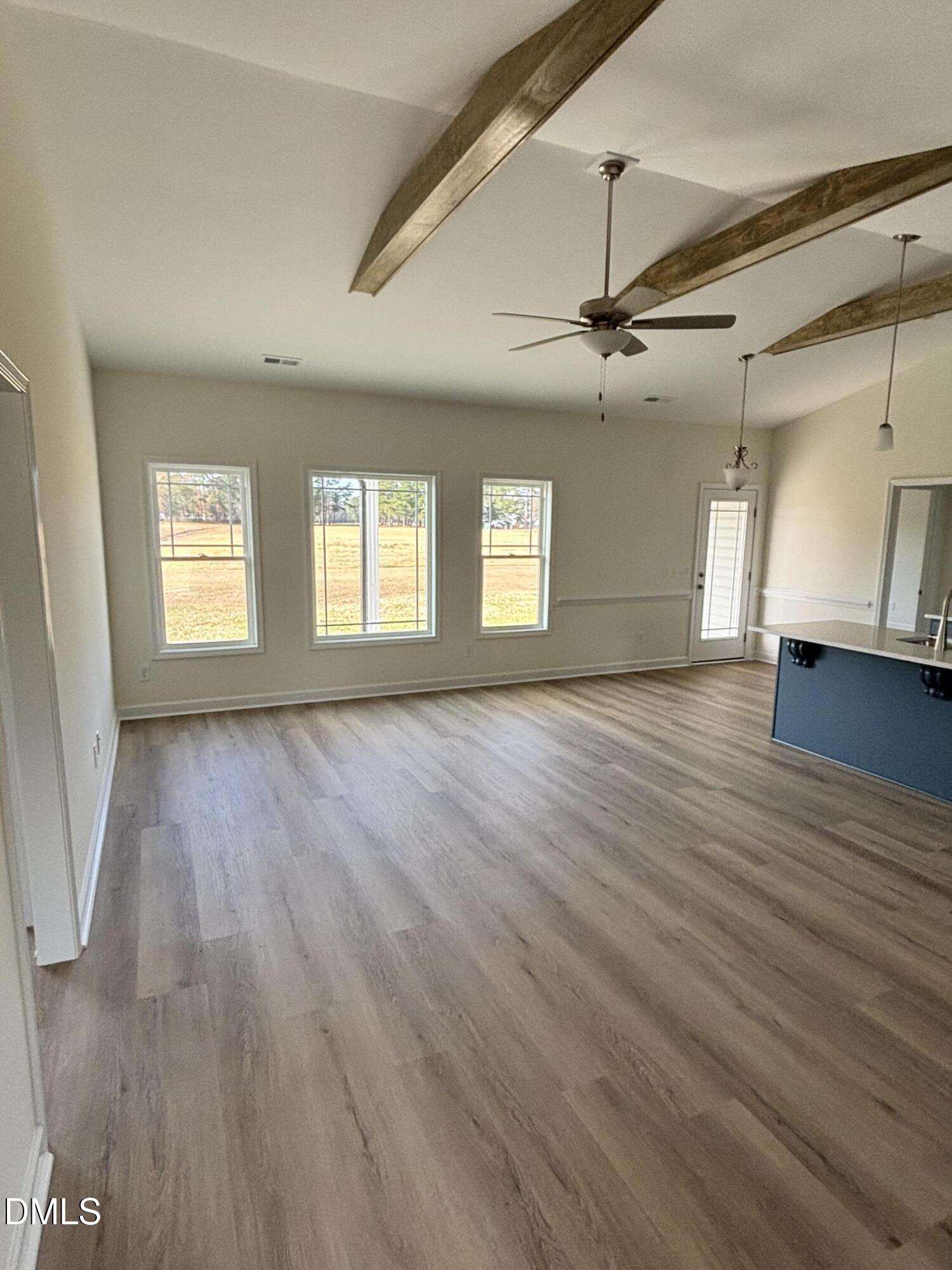 149 Budd Godwin Lane Dunn, NC 28334 - Photo 19 of 19 an empty room with wooden floor and windows