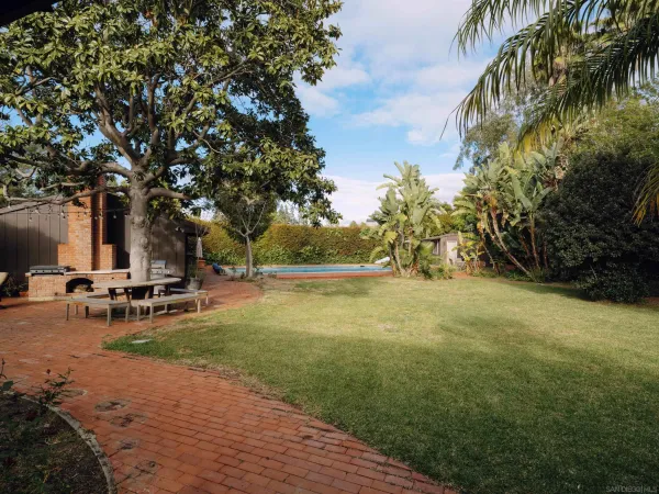 a view of backyard with swimming pool and sitting area