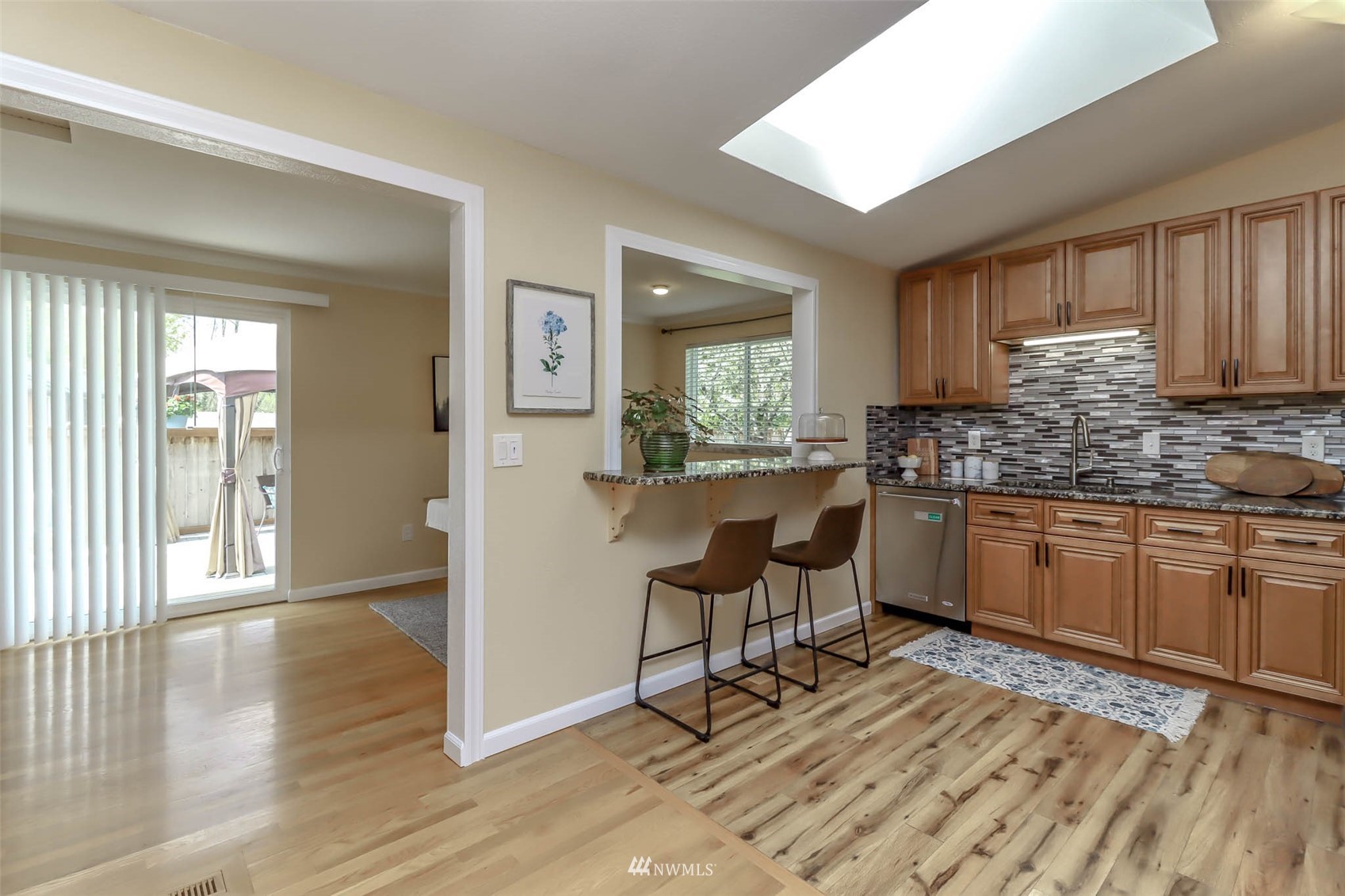 2221 182nd Street Southeast Bothell, WA 98012 - Photo 8 of 39 a kitchen with granite countertop wooden floors and white stainless steel appliances