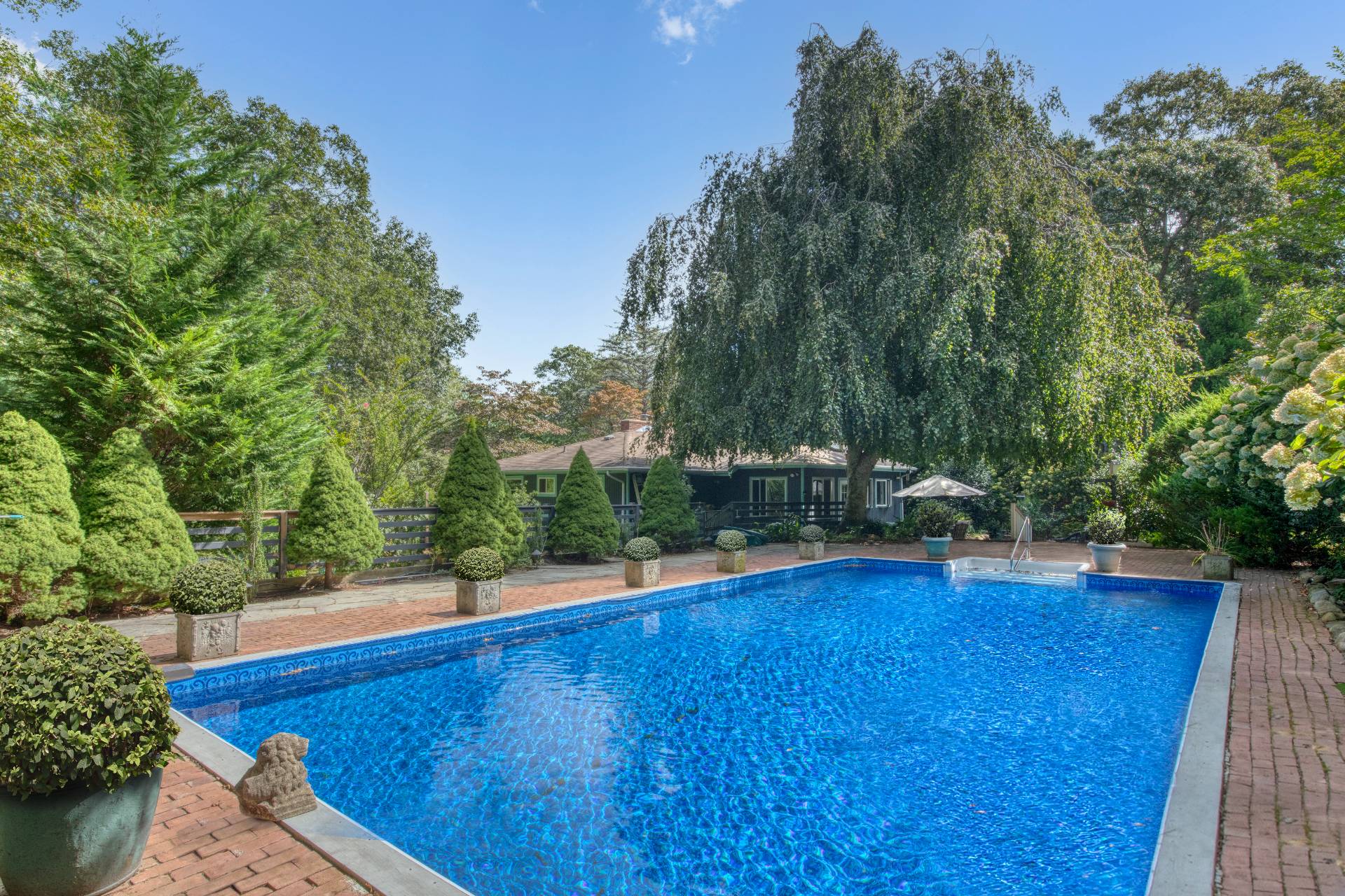 1 Abigails Path East Hampton, NY 11937 - Photo 2 of 18 a view of swimming pool with seating space and trees in the background