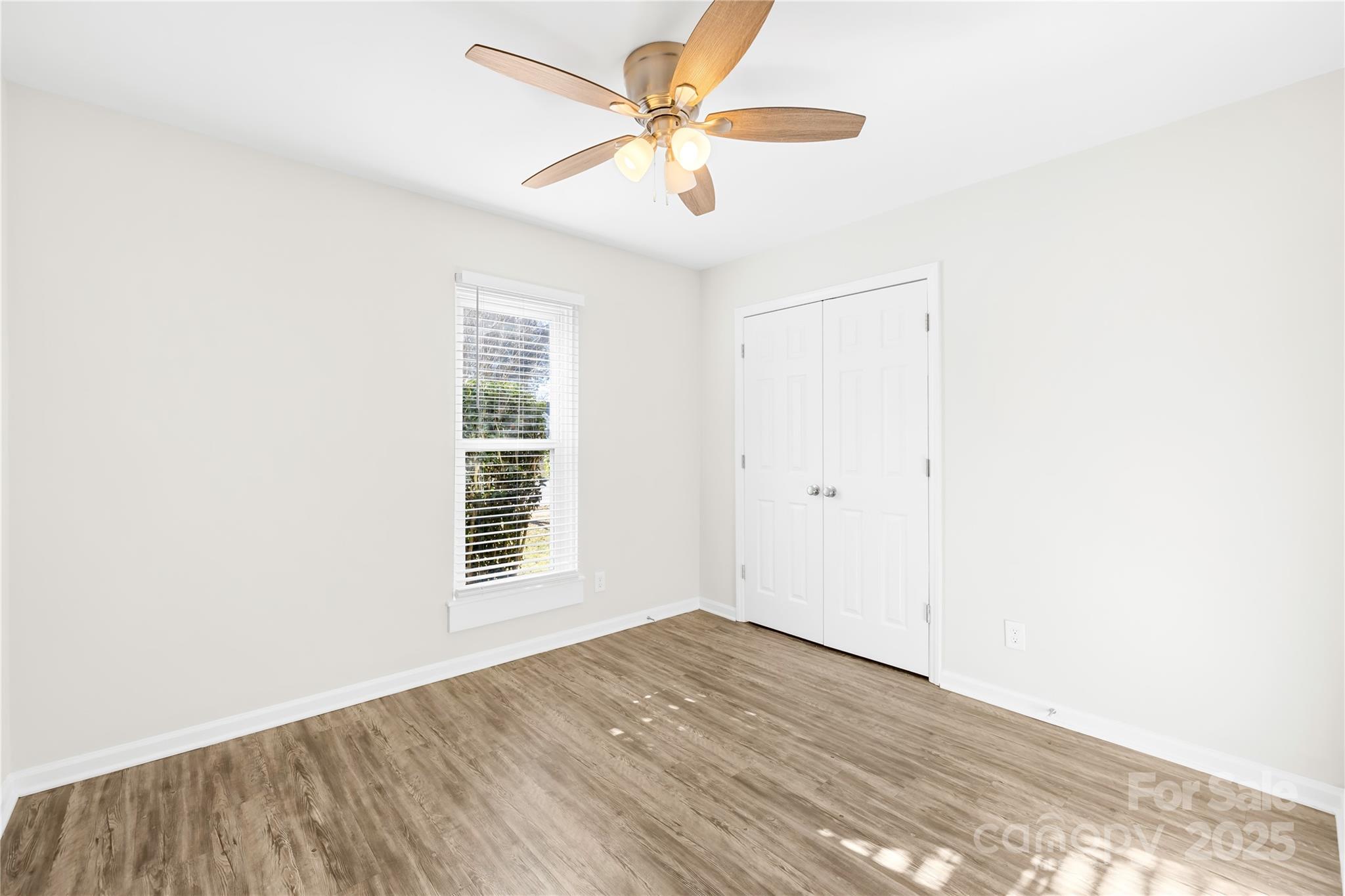 11816 Park Road Charlotte, NC 28226 - Photo 19 of 26 an empty room with wooden floor fan and windows