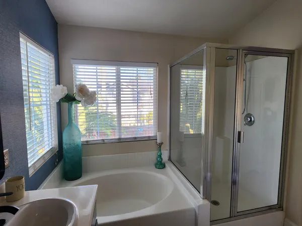 a bathroom with a granite countertop sink mirror and a bathtub