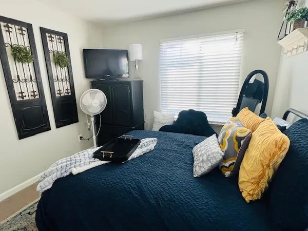 a bed room with a bed and painting on the wall