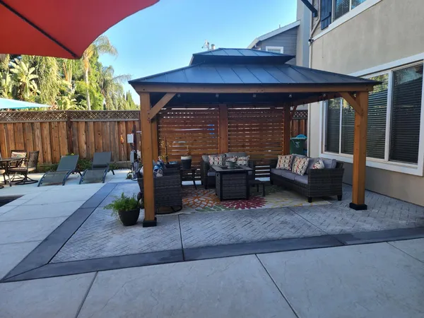 a view of a patio with table and chairs with wooden fence