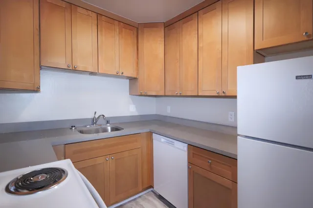 a bed sitting in a bedroom next to a window with a wooden floor