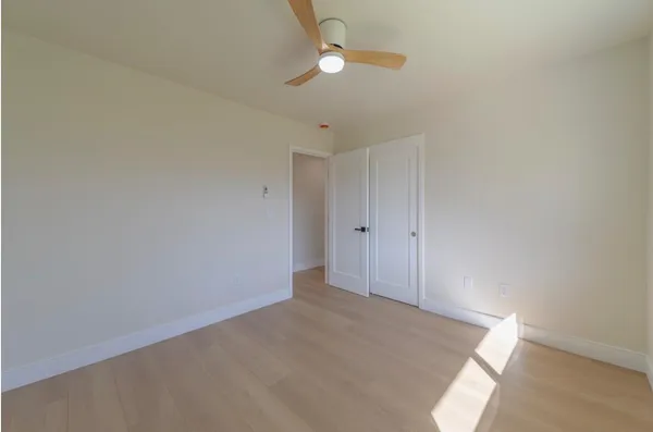 an empty room with a ceiling fan and a window