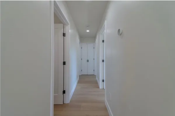 a view of a hallway with wooden floor