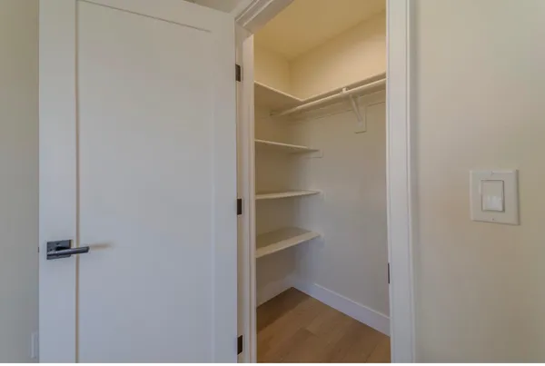 a view of walk in closet with empty racks