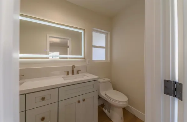 a bathroom with a toilet sink and mirror