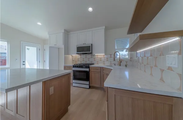 a kitchen with kitchen island granite countertop a sink stove and refrigerator