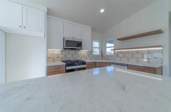 a view of kitchen with microwave and cabinets
