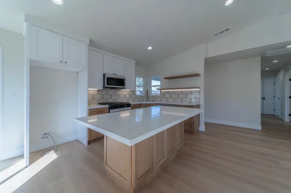 a kitchen with stainless steel appliances granite countertop a sink a microwave and cabinets