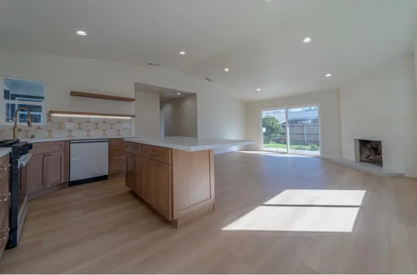 a kitchen with stainless steel appliances granite countertop a stove a sink and a refrigerator