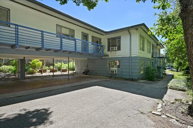 a front view of a house with a yard and potted plants