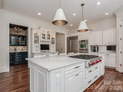 a kitchen that has a lot of cabinets in it and wooden floors