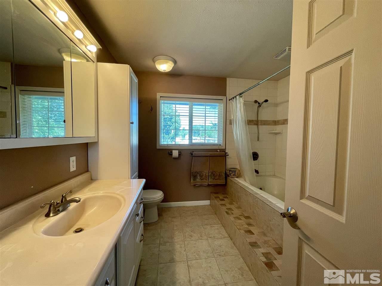 814 McLean Road Fallon, NV 89406 - Photo 18 of 40 a bathroom with a sink mirror toilet shower and bathtub