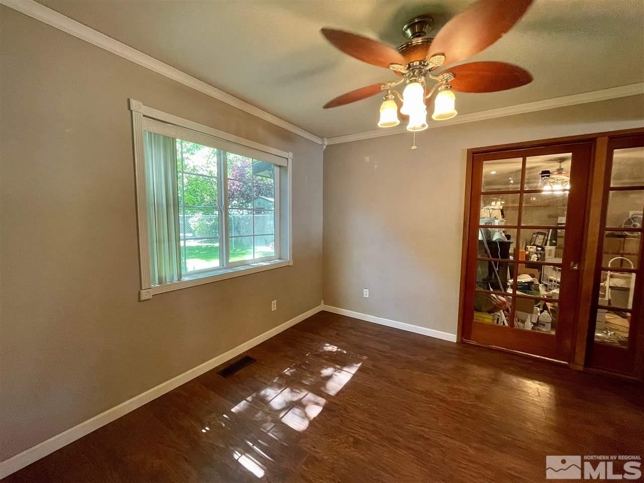 814 McLean Road Fallon, NV 89406 - Photo 6 of 40 a view of an empty room with window and wooden floor