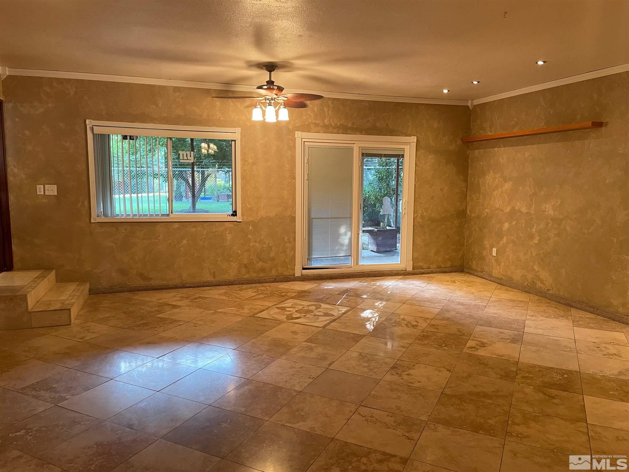 814 McLean Road Fallon, NV 89406 - Photo 8 of 40 a view of an empty room with a chandelier fan and a window