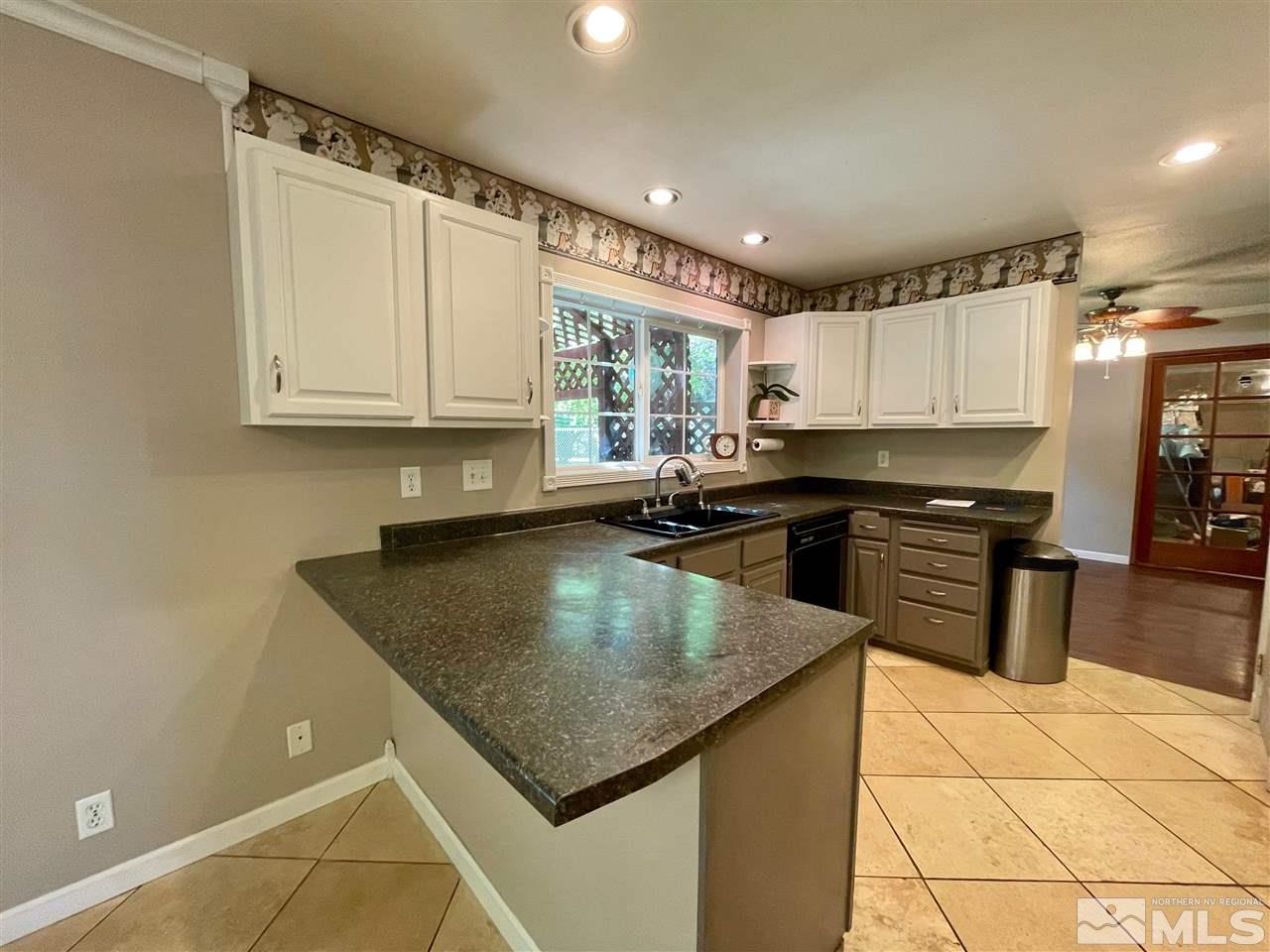 814 McLean Road Fallon, NV 89406 - Photo 10 of 40 a kitchen with granite countertop a sink a counter top space appliances and cabinets