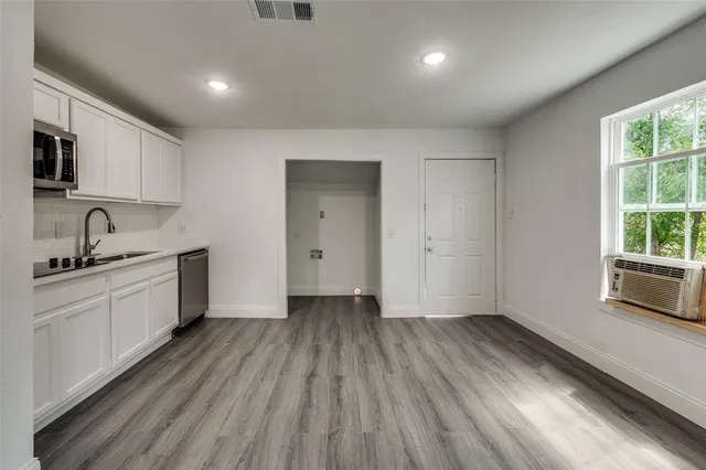 a view of a kitchen with sink cabinets and wooden floor