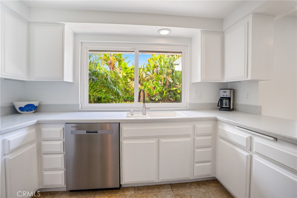 2204 Recodo Court Carlsbad, CA 92009 - Photo 12 of 44 a kitchen with white cabinets and a window