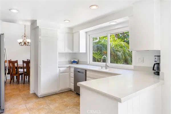 a kitchen that has a sink a stove and a refrigerator