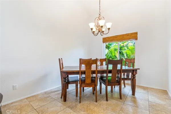 a view of a dining room with furniture a chandelier and window