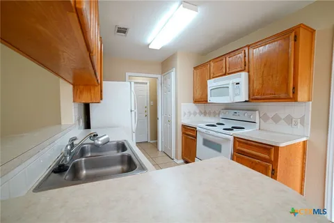 a kitchen with a sink stove and refrigerator