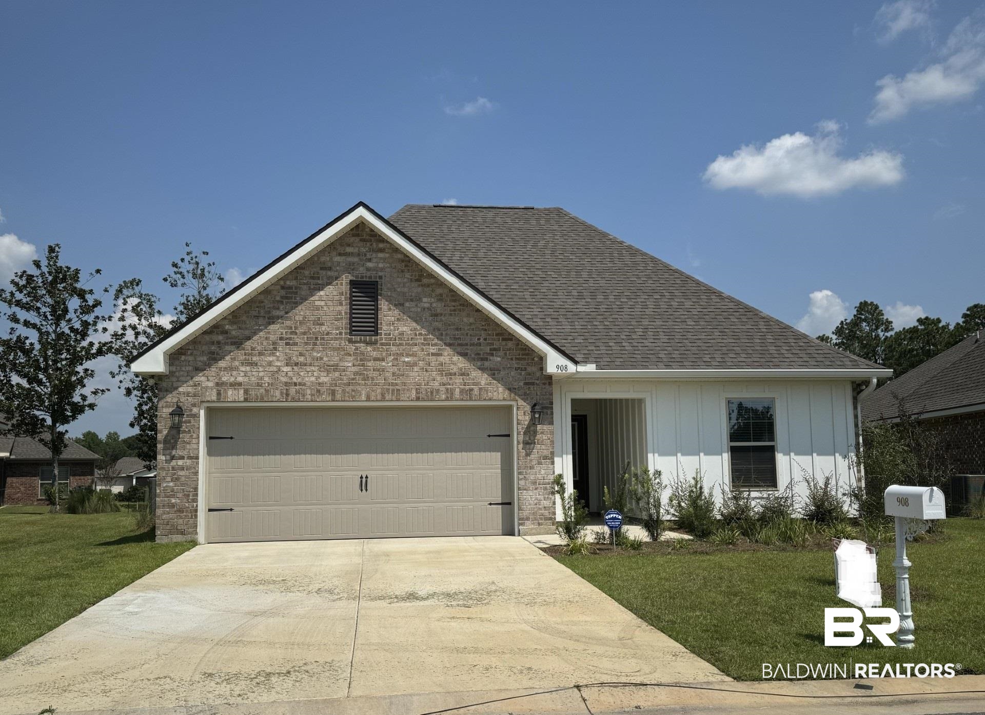 View of front of property with a front yard and a garage