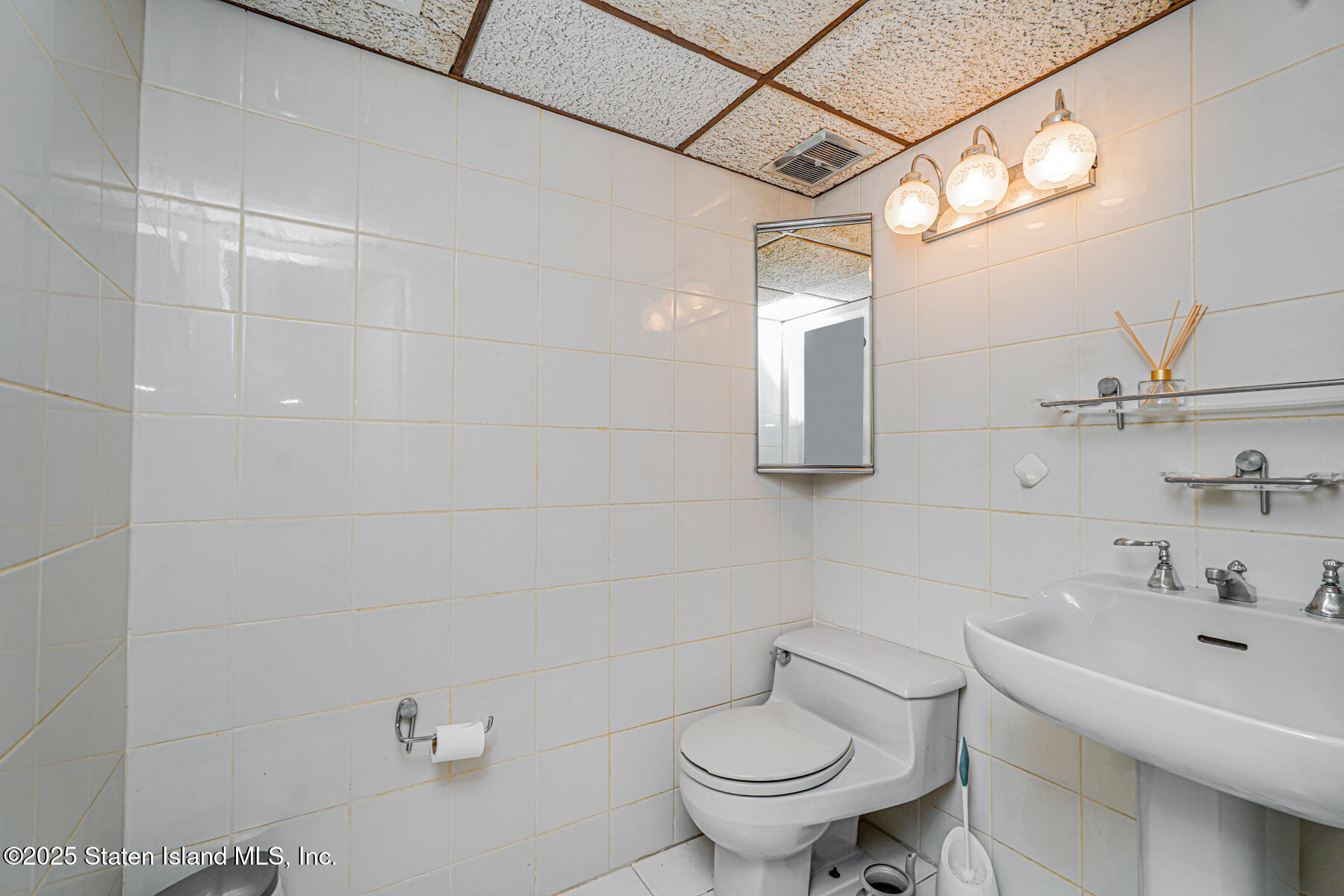 284 Todt Hill Road Staten Island, NY 10314 - Photo 27 of 29 a bathroom with a sink mirror and toilet