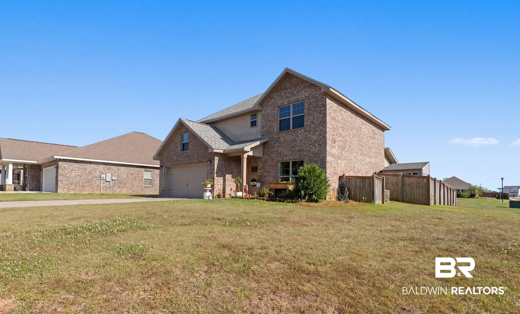 16607 Prado Loop Loxley, AL 36551 - Photo 3 of 46 Two-story brick residence featuring a two-car garage, covered entry porch, and a fenced side yard