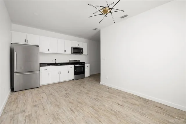 a kitchen with stainless steel appliances a refrigerator sink and cabinets