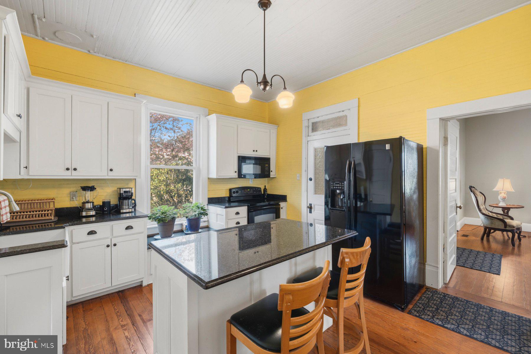 2136 Rocksprings Road Ringgold, VA 24586 - Photo 22 of 57 a kitchen with a refrigerator a sink dishwasher a stove and white cabinets with wooden floor