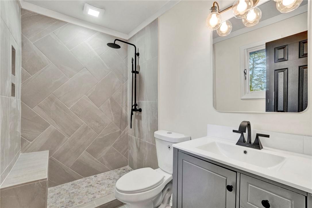 237 Earle Road Central, SC 29630 - Photo 15 of 24 A well-appointed bathroom features a spacious tiled shower with a convenient built-in bench and a sleek vanity.