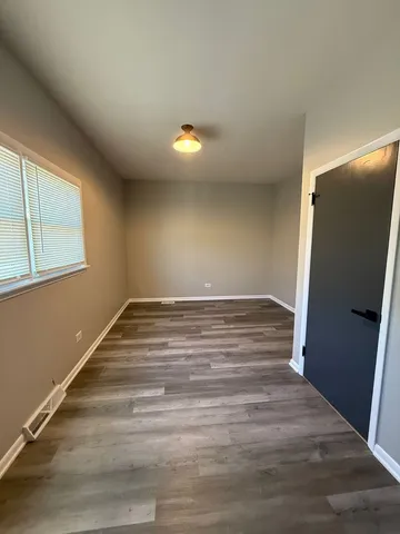 a view of an empty room with glass door and windows