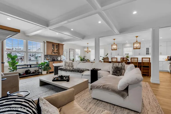 a kitchen with kitchen island a wooden floor and a view of living room