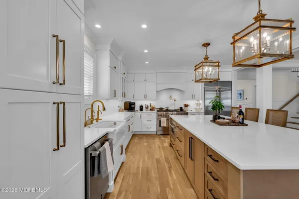 a kitchen with a dining table chairs cabinets and stainless steel appliances