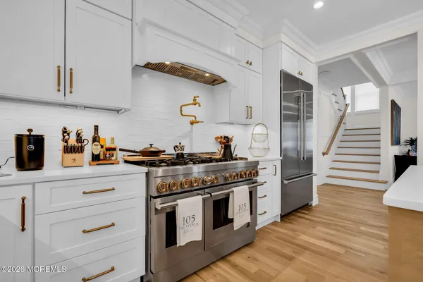 a dining room with furniture a kitchen and chandelier