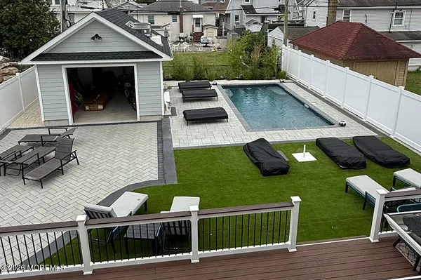 a front view of a house with swimming pool and chairs