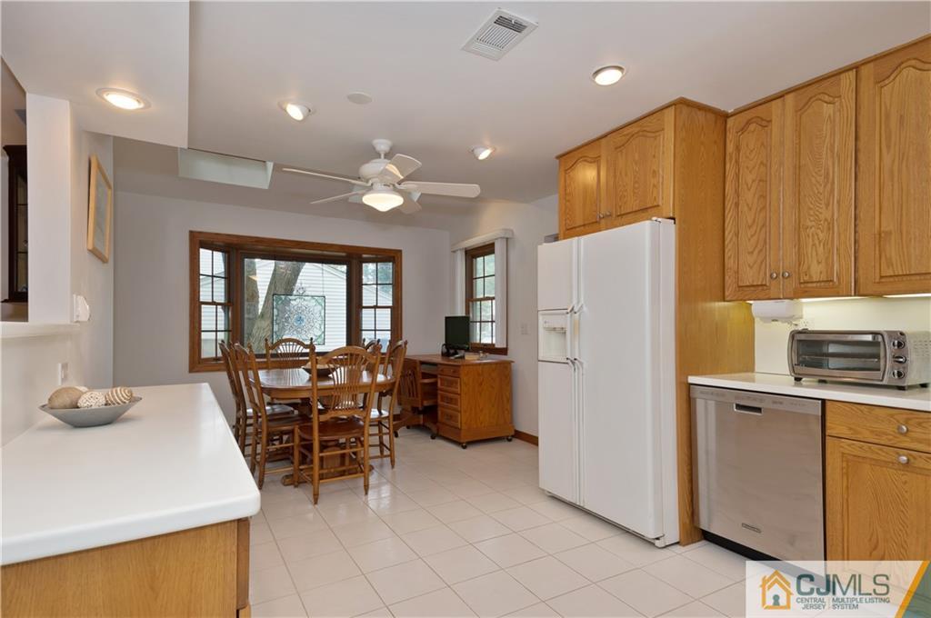 2 Doria Road Somerset, NJ 08873 - Photo 2 of 19 a kitchen with a refrigerator a stove top oven a sink dishwasher and dining table with wooden floor