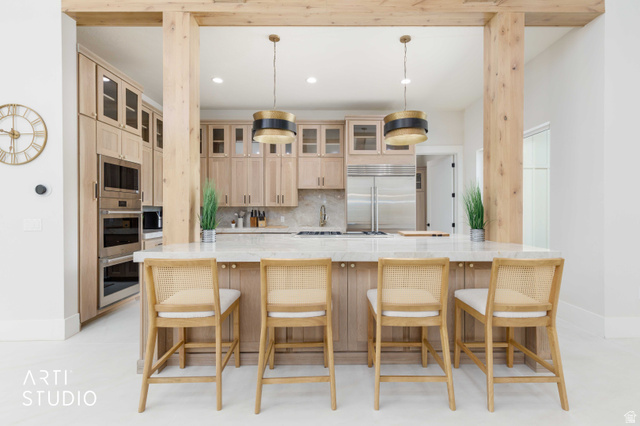 1188 South Old Trappers Loop Road Huntsville, UT 84317 - Photo 24 of 92 Spacious kitchen featuring a large central island with seating, natural wood cabinetry, integrated stainless steel appliances, marble countertops, and decorative pendant lighting