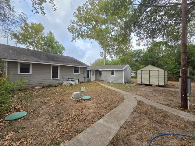a view of a house with a yard tree and wooden fence