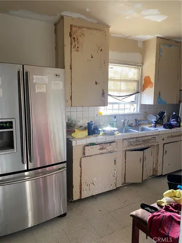a kitchen with stainless steel appliances a refrigerator sink and cabinets