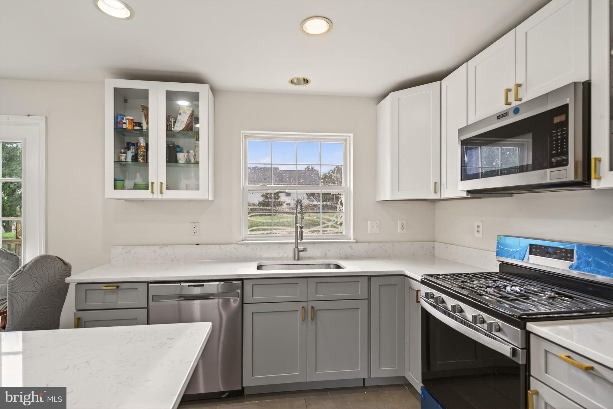 6903 Bock Road Fort Washington, MD 20744 - Photo 12 of 62 a kitchen with stainless steel appliances granite countertop a sink stove and microwave