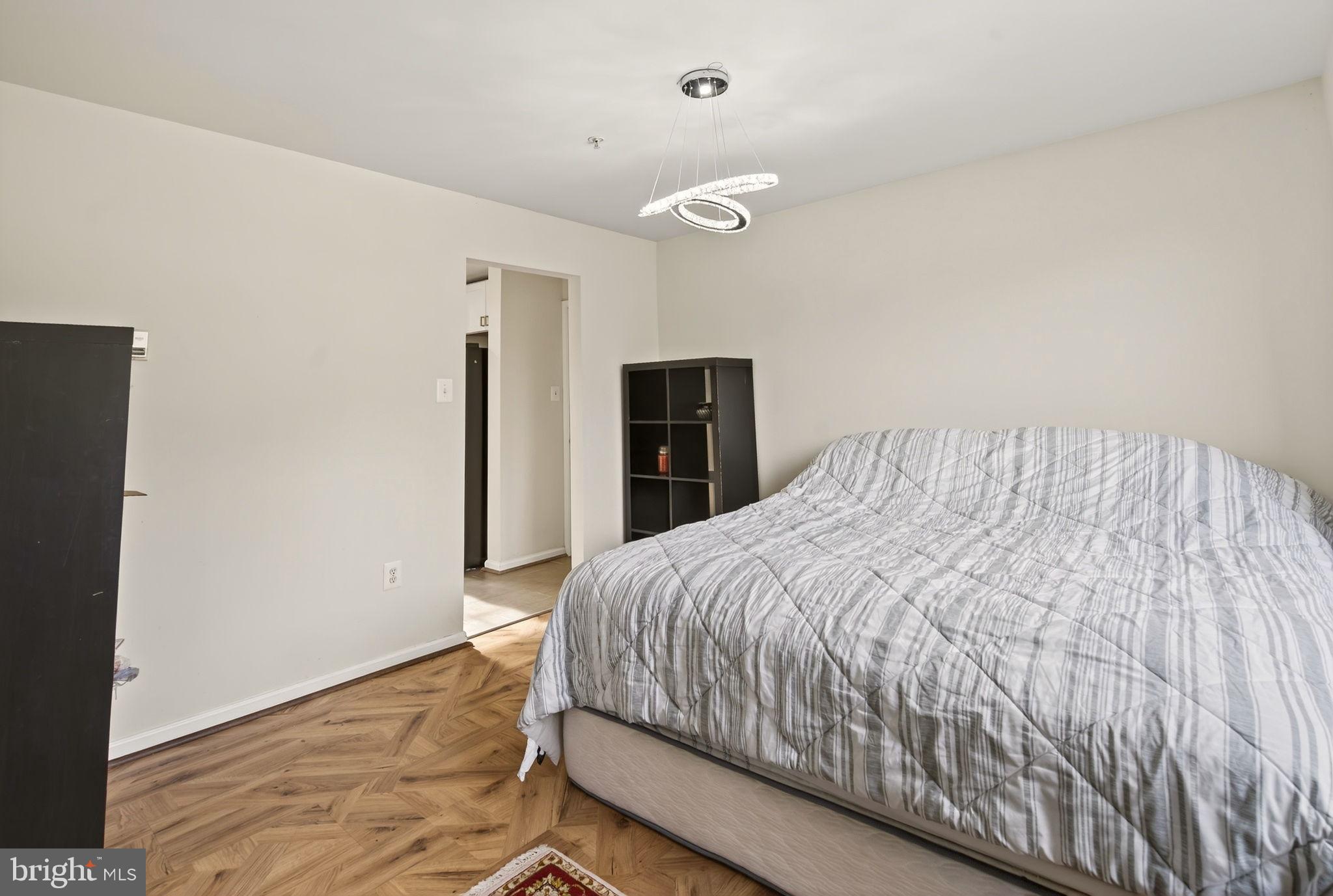 6903 Bock Road Fort Washington, MD 20744 - Photo 34 of 62 a bedroom with a large bed and a chandelier