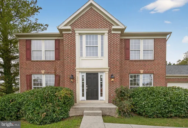 front view of a brick house with a yard
