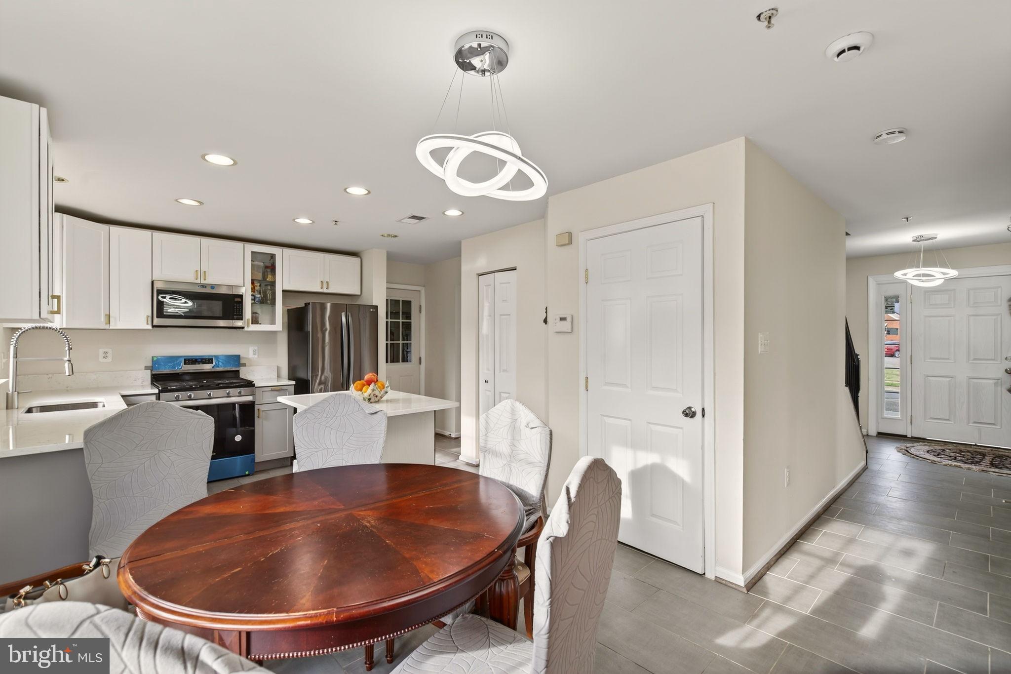 6903 Bock Road Fort Washington, MD 20744 - Photo 48 of 62 a kitchen with stainless steel appliances granite countertop a sink a stove a refrigerator cabinets and living room view