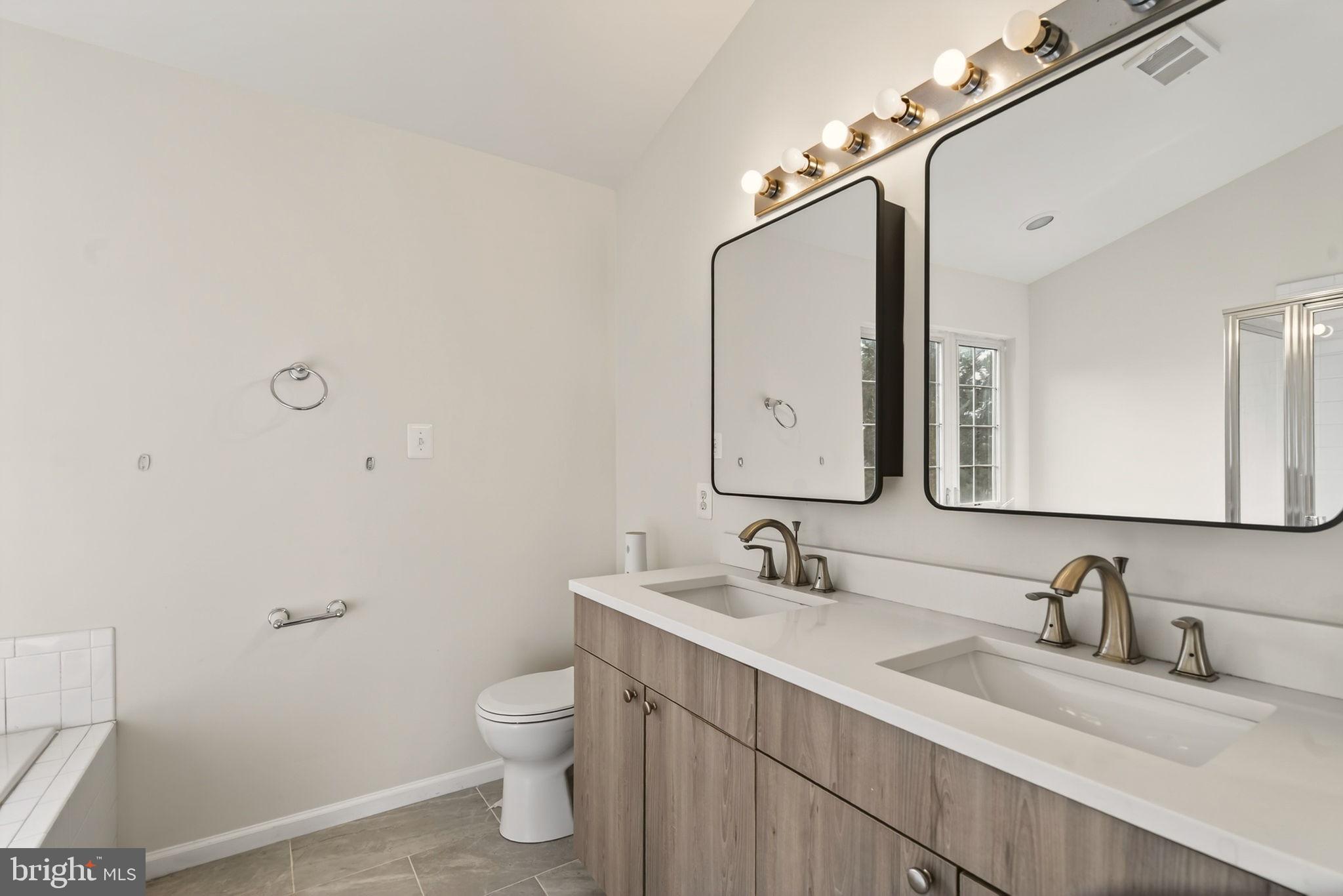 6903 Bock Road Fort Washington, MD 20744 - Photo 55 of 62 a bathroom with a granite countertop sink a toilet and a mirror