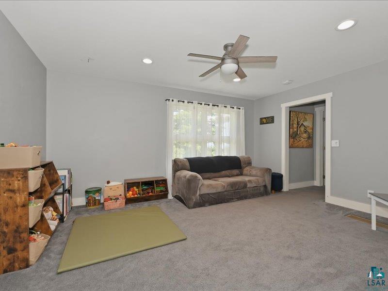88440 Huron Street Cornucopia, WI 54827 - Photo 22 of 44 Recessed lighting illuminates this room featuring gray walls and gray carpet.